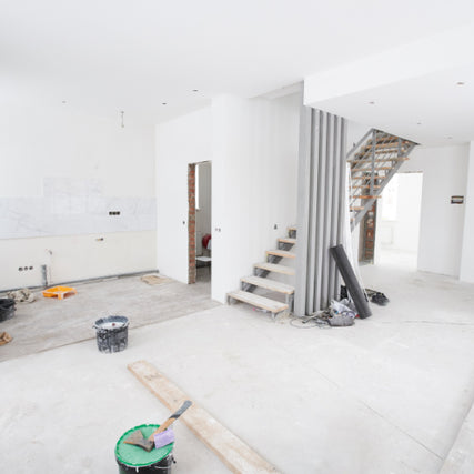 ContractorsBright, open interior under renovation with unfinished walls and flooring. Scattered tools and materials evoke a sense of progress and anticipation.